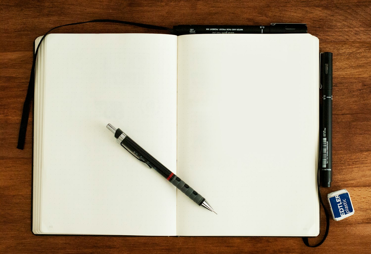 A pen resting on a blank notebook, ready for a meeting agenda