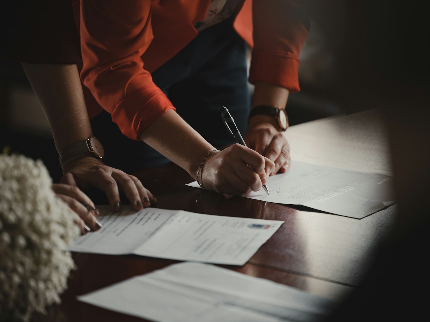 A person filling out paperwork at a desk, as when completing a VA disability claim application