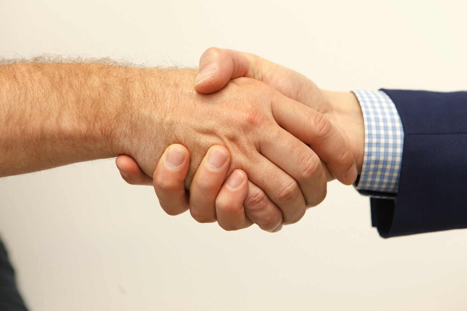 Two people shaking hands, as when an employee is welcomed back after service