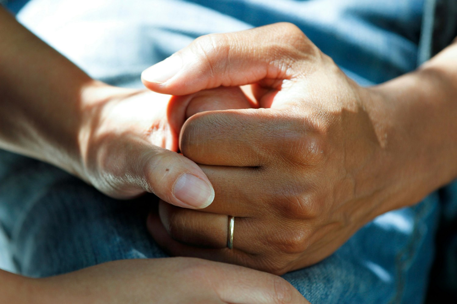 Hands held together in support, representing family involvement in long-term care decisions