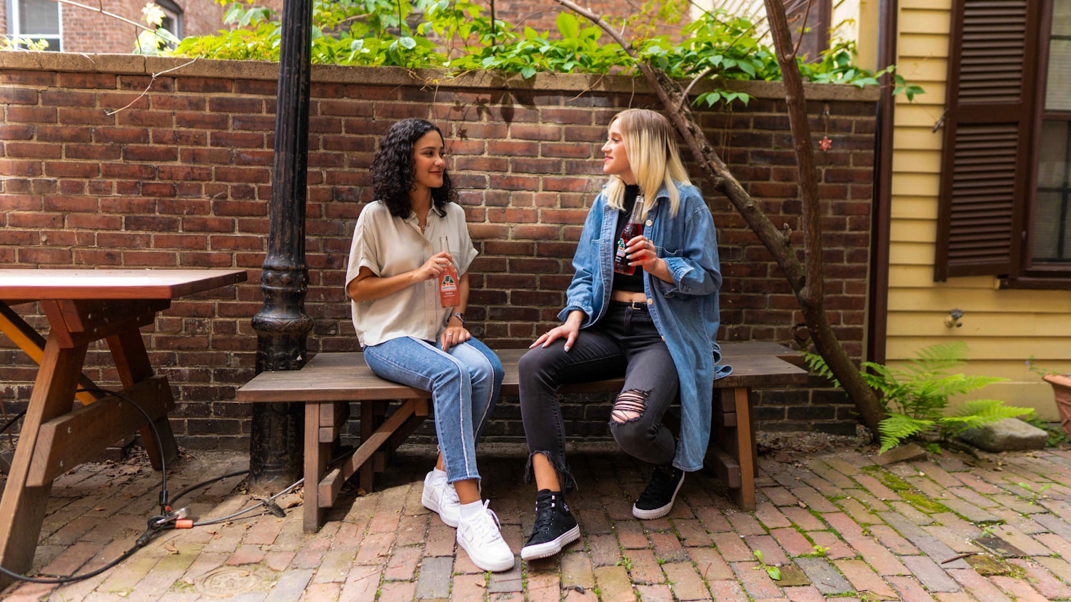 Two people sitting together on a bench in conversation, listening without interrupting