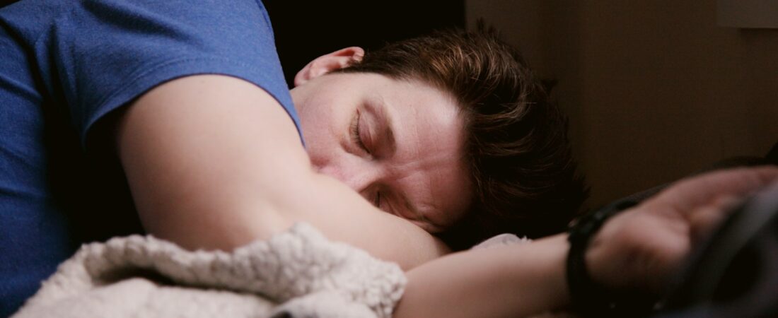 A man asleep in bed, representing the disrupted rest sleep apnea causes