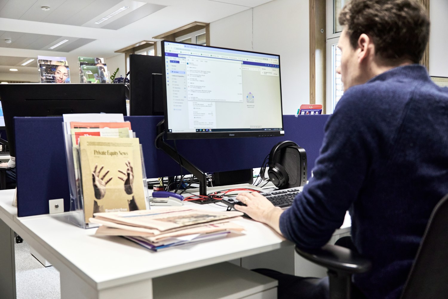 A man working at a computer in an office, the civilian job USERRA restores