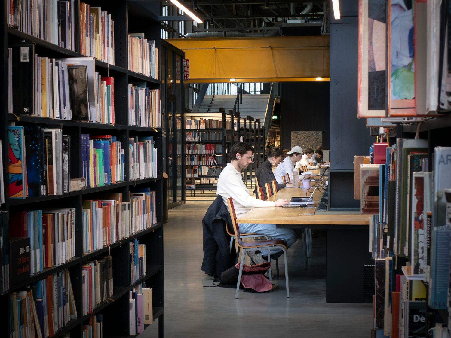 People studying at tables in a modern library
