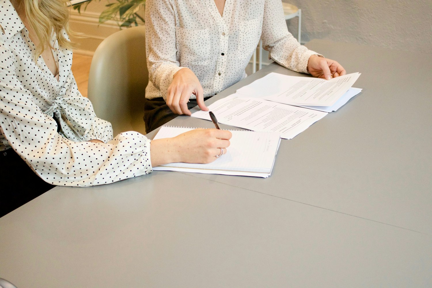 Two people reviewing and signing mortgage loan documents at a table