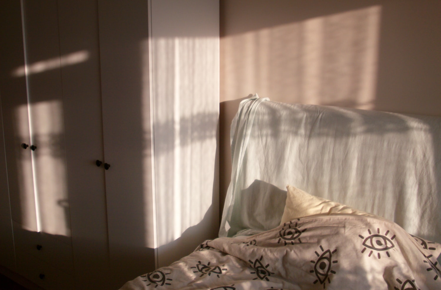 Sunlight streaming across a bed in the morning