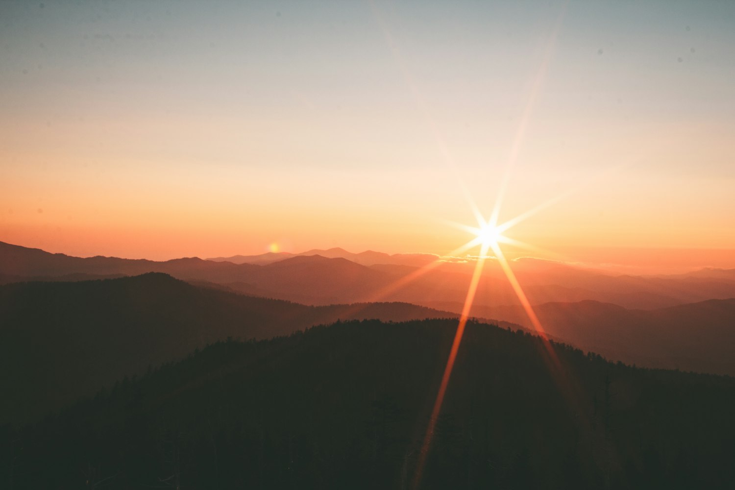 Mountains silhouetted at sunrise, representing hope and a new day