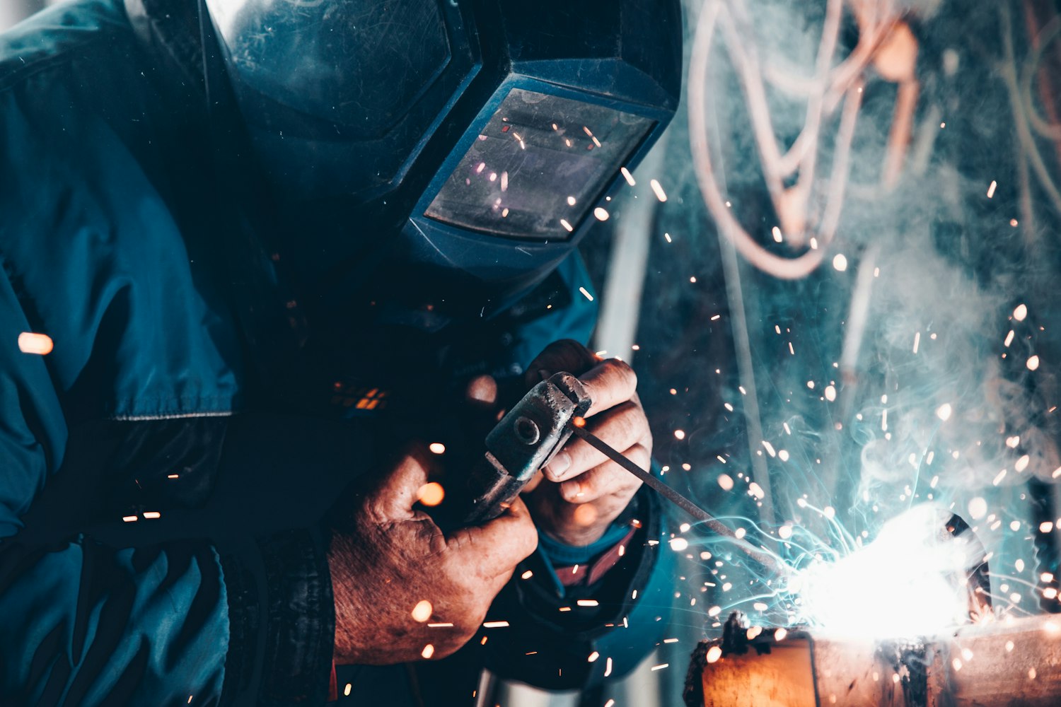 A person welding at a trade school, one of the training paths GI Bill benefits cover
